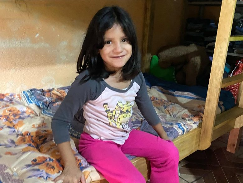 A young girl smiling on her new bed